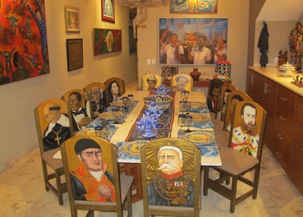 Dining table and chairs decorated in colorful Mexican artwork at La Casa de los , Valladolid, Yucatan
