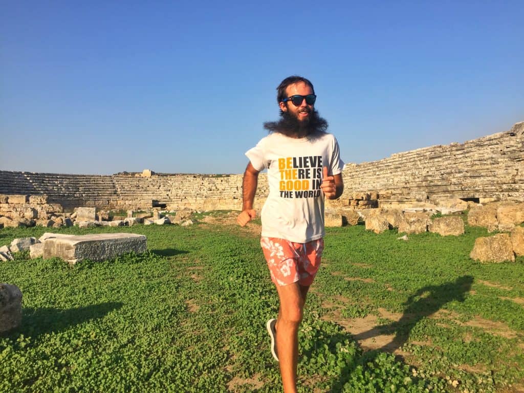 man with beard running at a Roman stadium